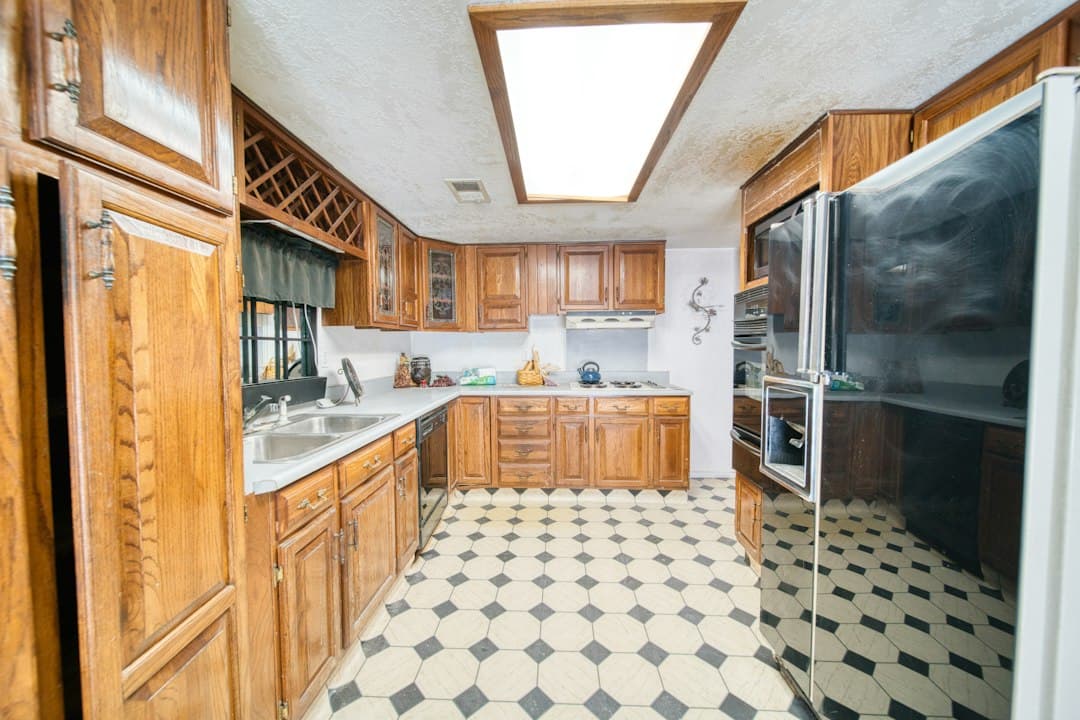 Dated kitchen with dark wood cabinets and checkered floor